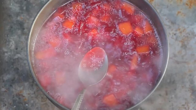 A Hand Mixing Boiling Beetroot Soup (Borscht) With Spoon