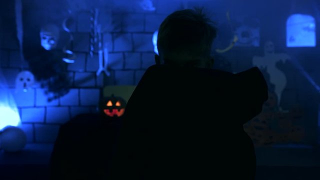 Young boy in a vampire costume for Halloween showing his scary face and teeth to camera