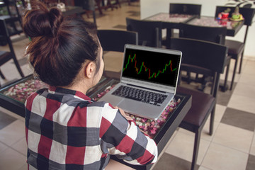 Forex concept : Business woman working with stock trading forex on laptop at coffee shop