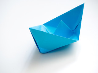 Single Blue paper boat on white