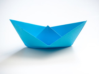 Single Blue paper boat on white