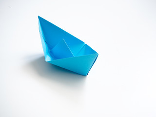 Single Blue paper boat on white