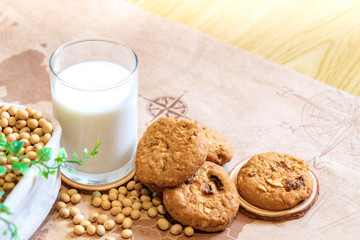 Soy milk in glass and cookie with soy bean on bucket at morning time. Nature healthy concept.