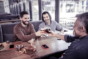 Joyful young male person spending time with colleagues