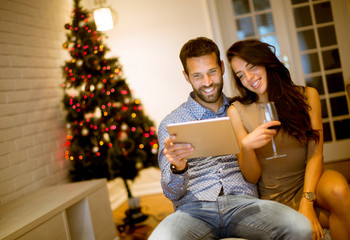 Handsome young couple with tablet at New Years eve