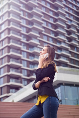 Obraz premium Young business woman uses cellphone at the street