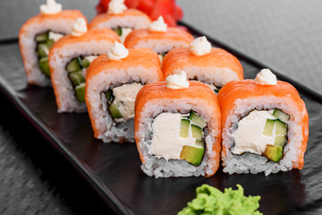 Philadelphia roll with salmon and cucumber. Maki Sushi set on dark pattern background. Sushi Set...