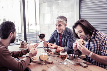 Cheerful males talking about hobbies during pause