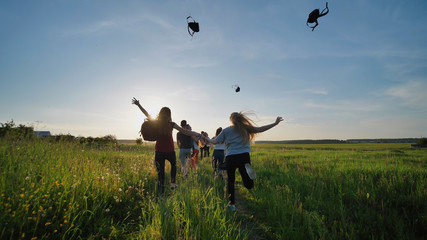 Happy senior pupils flee and toss their portfolios against the sunset. Happy ending school days....