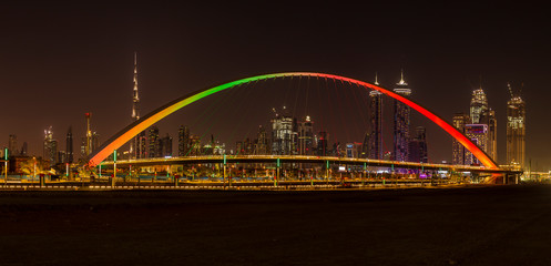 Tolerance Bridge in Dubai at night with impressive Dubai skyline in the background