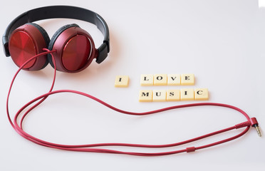 Flat lay of red headphone and its cable with western scripts say I love music.