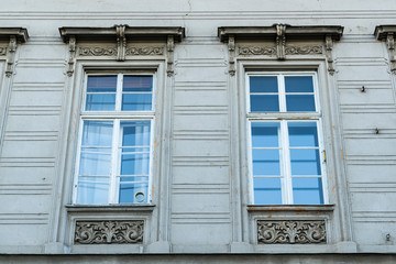 Fototapeta na wymiar Stone wall texture of a house with white vintage windows. Exterior of an European house