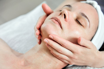 Fototapeta na wymiar Face massage. Facial skincare. Hands of masseur. Woman at beauty spa salon. Skin Moisturizing Procedure