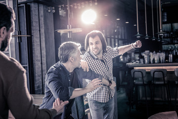 Angry two males having quarrel in pub