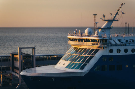 Close up view of ferry wheelhouse with large windows, antennas, megaphone against passenger gate