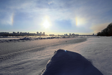 Winter cityscape at sunset, houses on the background of a halo - an interesting natural phenomenon....