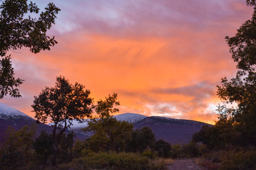 VIEW OF THE SUNSET IN THE SNOWY MOUNT OF MONCAYO IN ARAGON SPAIN IN A DAY OF AUTUMN WITH ORANGE CLOUDS IN THE SKY