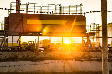 pressure vessel behind a barbed wire fence in the sunset