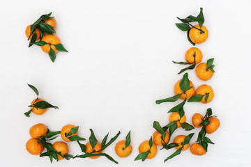 Fototapeta premium Fresh citrus fruits tangerine or mandarin on white background. Flat lay. Copy space. Frame from bright tasty tangerines.