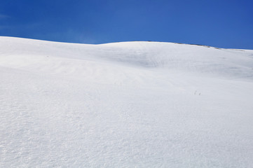 Fototapeta na wymiar mountain covered with snow under blue sky 