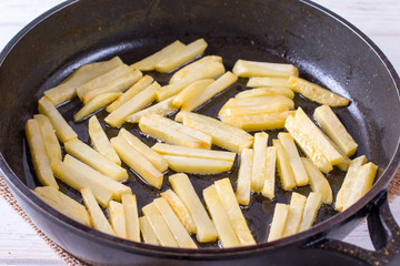 Potato fried in frying pan on table