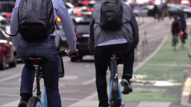 Slow motion of people riding a bike in the city to go to work. Sustainable transportation concept, smart people that cycle go faster than cars.