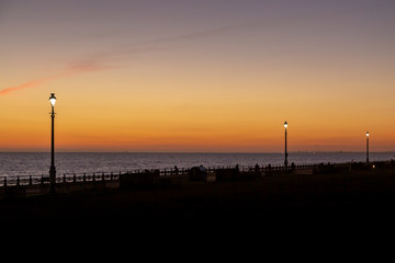Street lamps on Brighton seafront at sunset