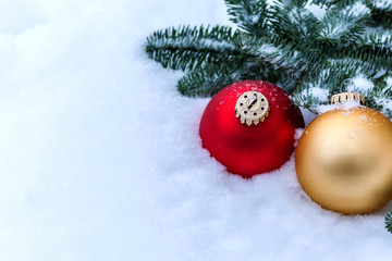 Multicolored Christmas toys on the background of snow and Christmas tree branches