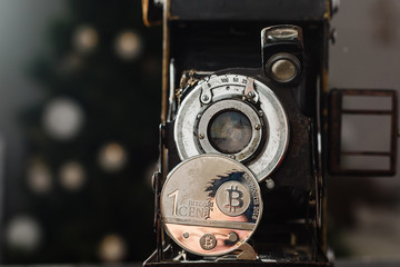 Camera can make money. Concept of Golden bitcoin coins symbolizes elements of virtual economy or crypto currency and vintage film camera