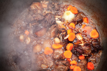 Lamb with vegetables stew in a cauldron