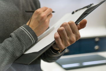 Businessman Holding A Clipboard And Writing