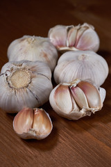 Garlic and garlic cloves on wooden background. Selective focus