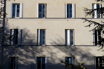 Fototapeta premium Façade crème volets ouverts, immeuble ancien