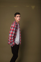 The portrait of young white boy looking aside posing isolated over green wall background