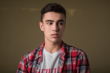 The portrait of young white boy looking aside posing isolated over green wall background