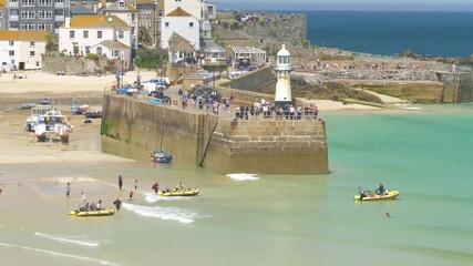 Tourists taking dinghy boat rides from St Ives beach on a super hot day during the British heatwave of 2018.