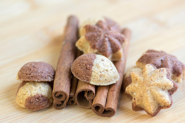Cinnamon sandbakelse christmas cookies, two colors, cocoa dark brown and vanilla light golden brown, cinnamon raw bark spice
