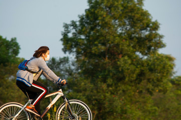 Obraz premium NAKHON PHANOM, THAILAND - OCT 11, 2018 : woman riding a bicycle in a park