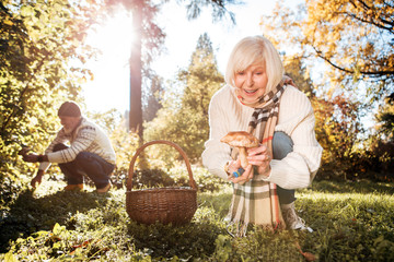 Nice delighted woman holding a beautiful mushroom