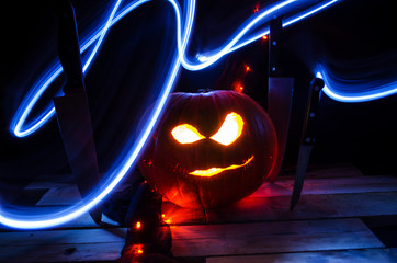 Long Exposure Light Trail with Glowing Carved Pumpkin and Knives at Night