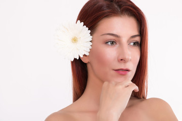 Portrait of beautiful redhead woman with white flower in her hair.