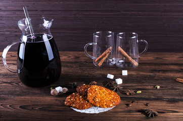 Jug of mulled wine, Cooking with spices, cardamom, cinnamon on kitchen table background