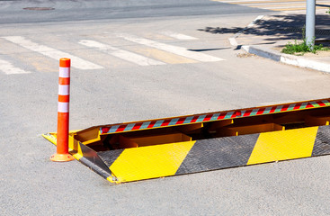 Road barrier with yellow and black striped caution pattern