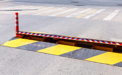 Road barrier with yellow and black striped caution pattern