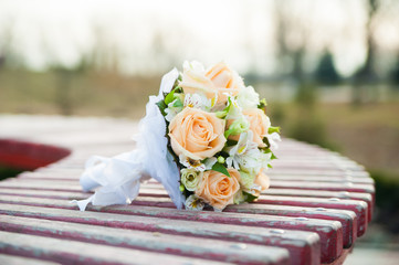 wedding bouquet lies on a wooden bench
