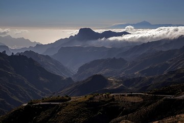 View from Cruz de Tejeda into the Teide Bay, Barranco de Tejeda, Altavista mountain and Tenerife island with Teide volcano, trade wind clouds, evening light, Gran Canaria, Canary Islands, Spain, Europe