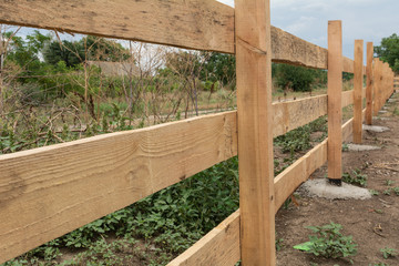 Ranch style fence. Rural wooden fence on green grass at farm ranch land in Shagany, Ukraina.