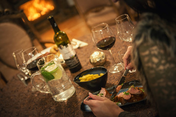 pretty woman drinking red wine and eating in restaurant, winter time, romantic dinner