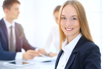 Fototapeta premium Group of business people or lawyers discussing terms of transaction in office. Focus at young business woman. Meeting and teamwork concept