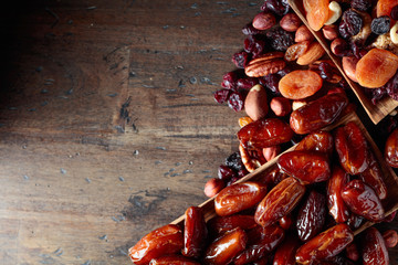 Various dried fruits and nuts in wooden dish.